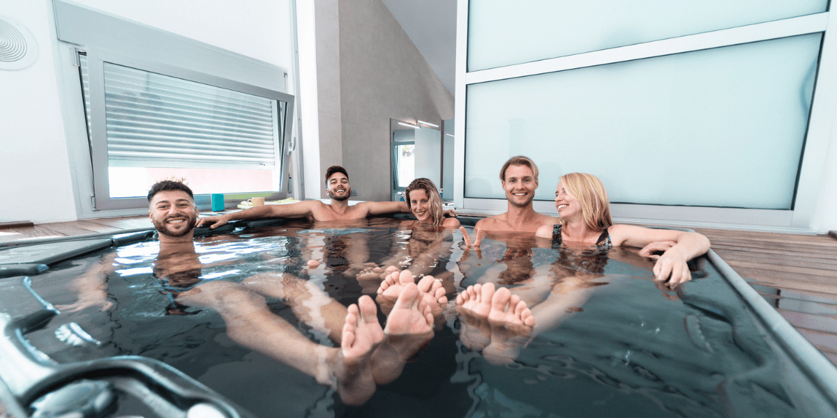 Friends having fun playing games in a hot tub, enjoying a lively and relaxing time together.