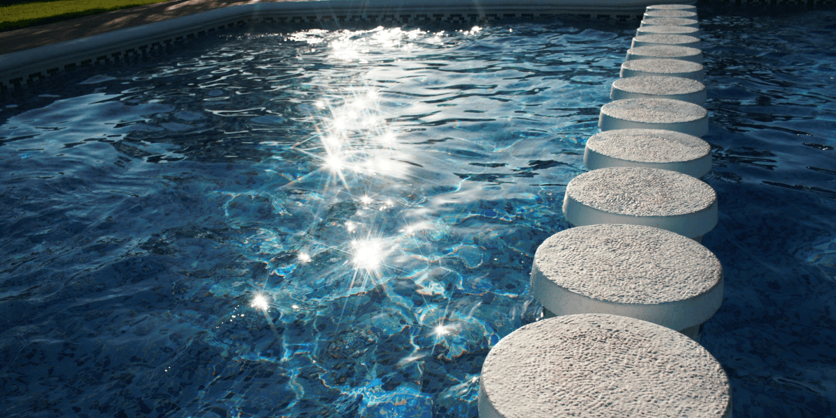 Sunrise reflecting on the water in a peaceful swimming pool.